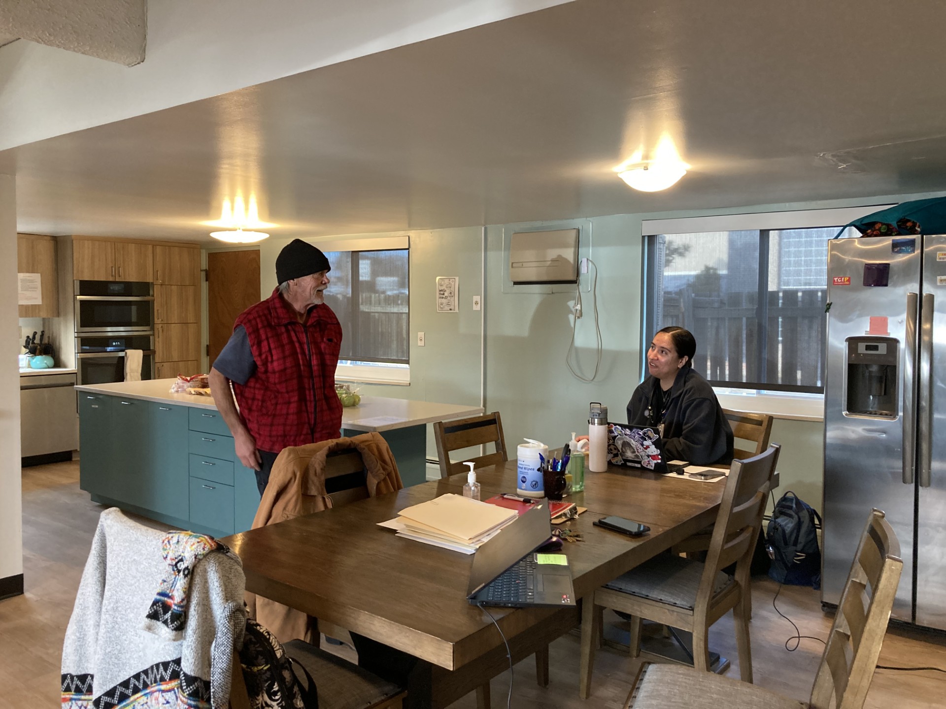 Guest talking to staff at kitchen table